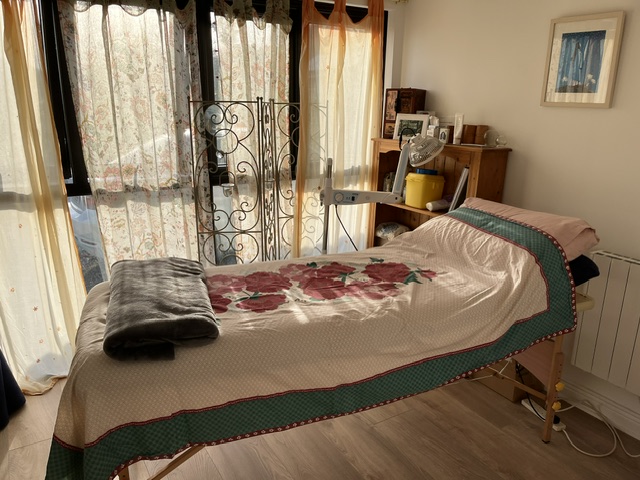 Acupuncture treatment room at Danu Lodge — wrought iron and floral linens
