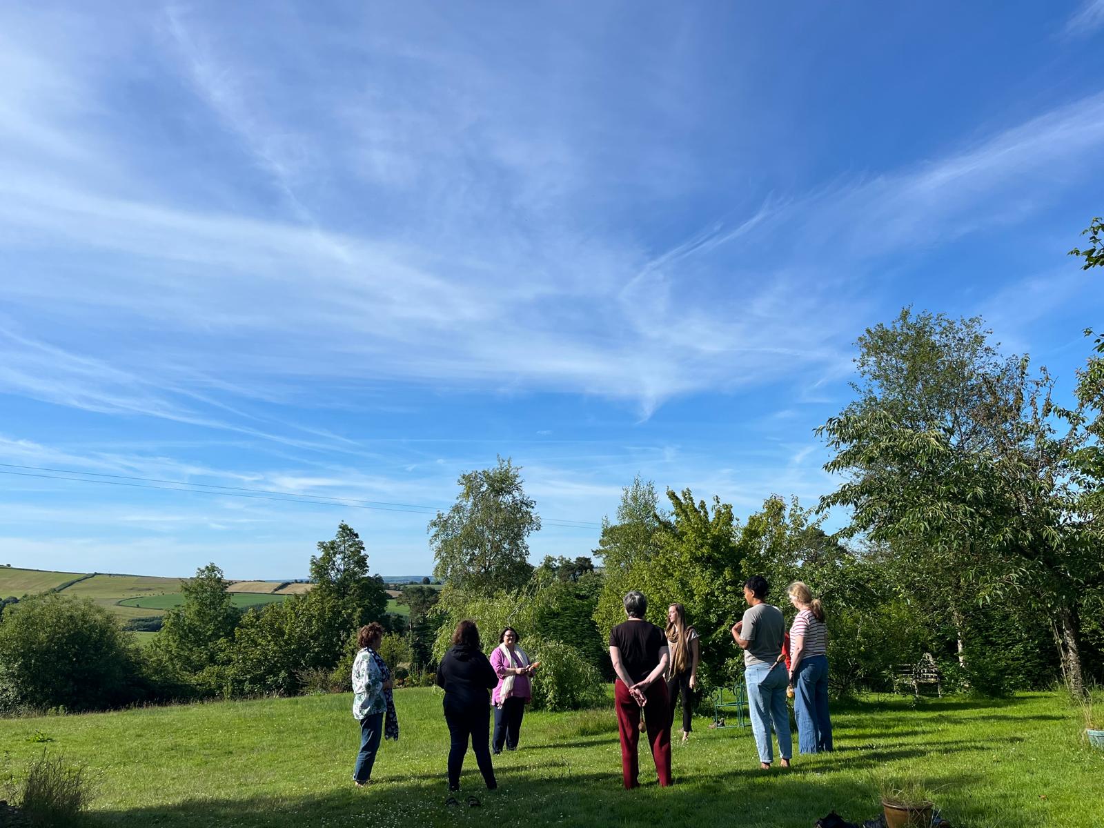 A circle standing in the garden under a wide summer sky