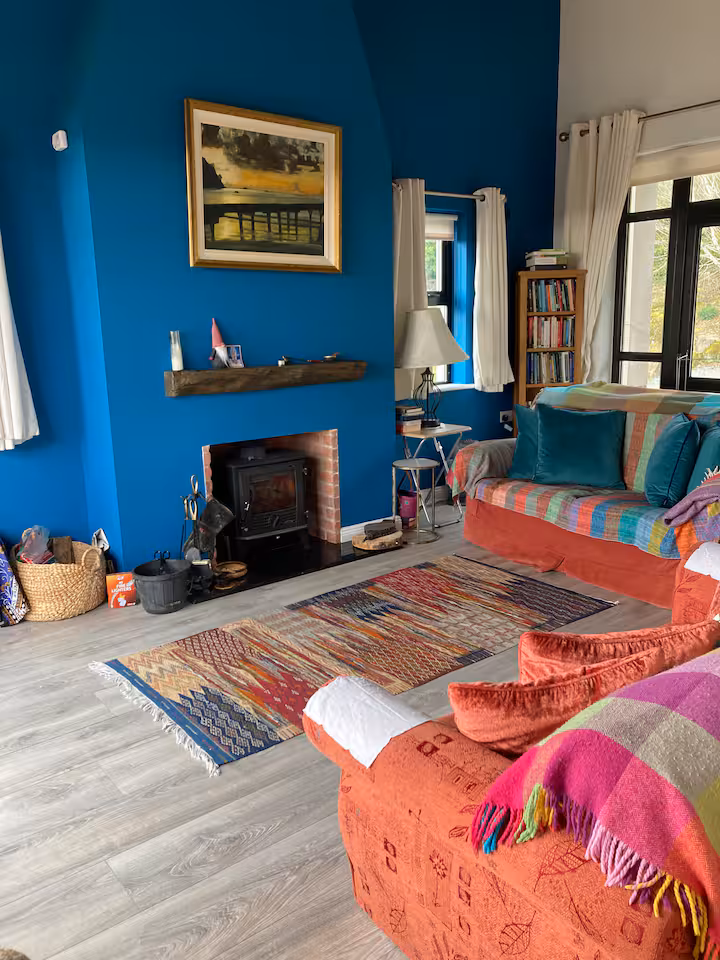 The blue sitting room — woodstove, kilim, quiet