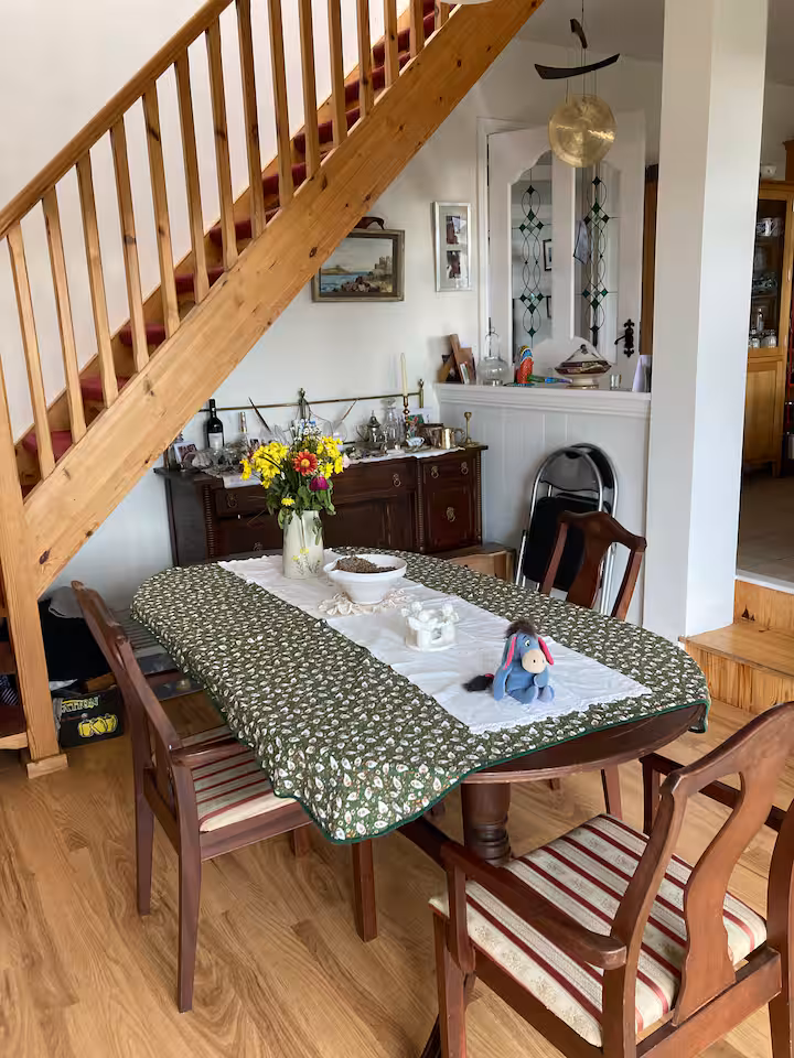 Inside the cottage — the table set beneath the stairs