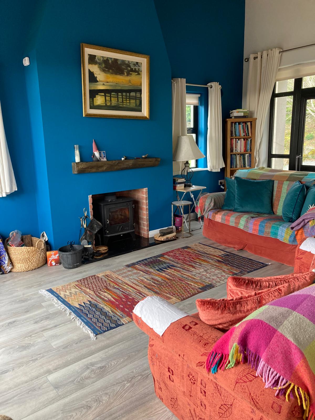 The teal room by the woodstove — kilims, blankets and a slow fire